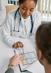 GP reading a chart to a patient