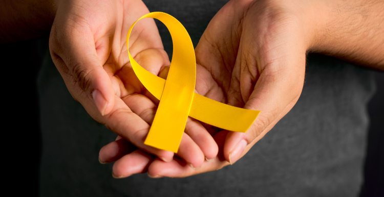 hands together holding a yellow ribbon