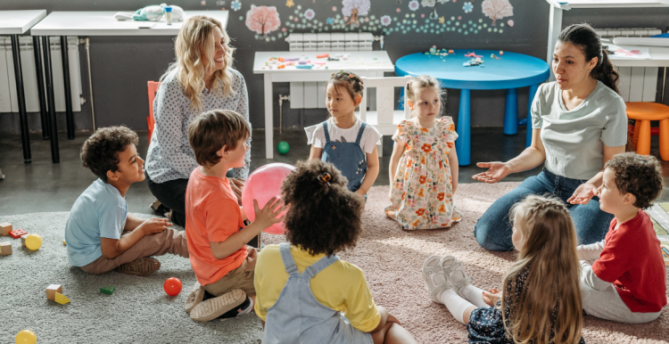 children in a circle with two adults playing games