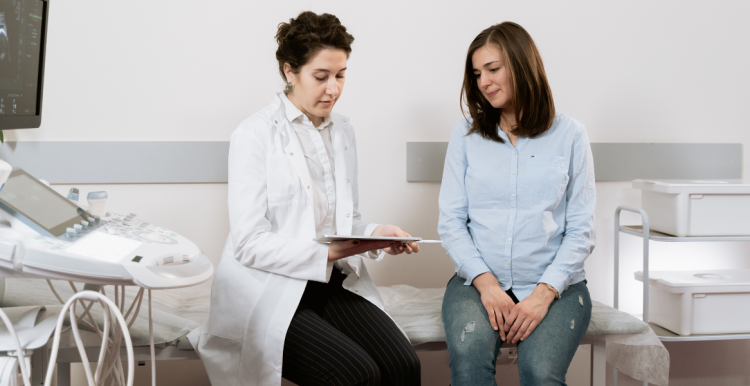 women talking on a hospital bed about pregnancy