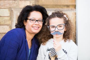 Woman and girl with paper moustache