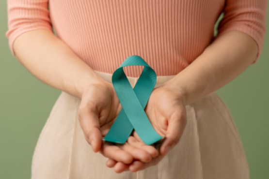 women with her hand together in front with a blue ribbon for cancer awareness in her hands